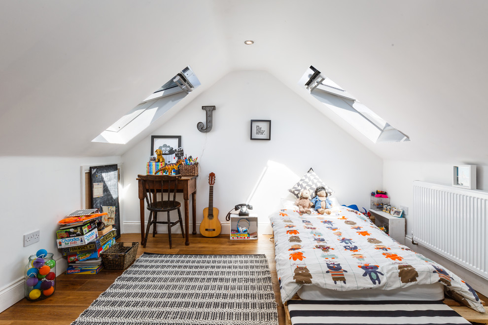 This is an example of a scandi children’s room for boys in London with white walls and medium hardwood flooring.