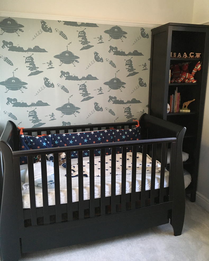 Cette image montre une petite chambre de bébé garçon design avec un mur bleu.