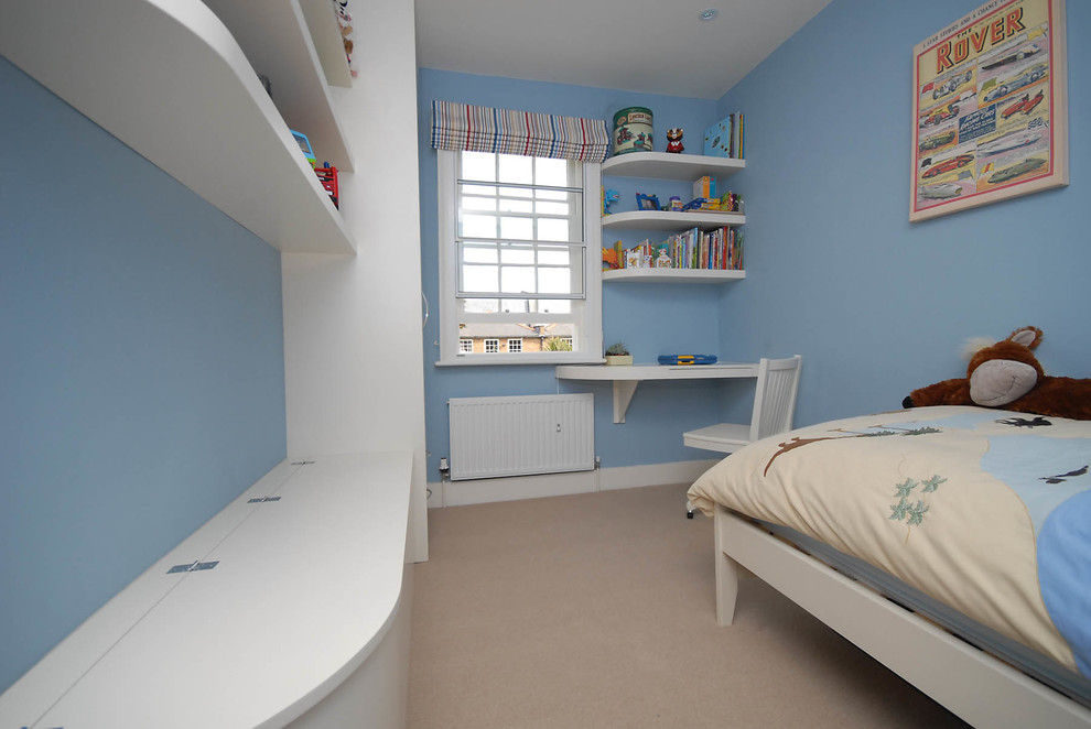 Kids' room - small modern boy carpeted kids' room idea in London with blue walls