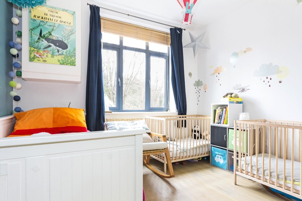 Foto på ett vintage könsneutralt småbarnsrum kombinerat med sovrum, med blå väggar och ljust trägolv