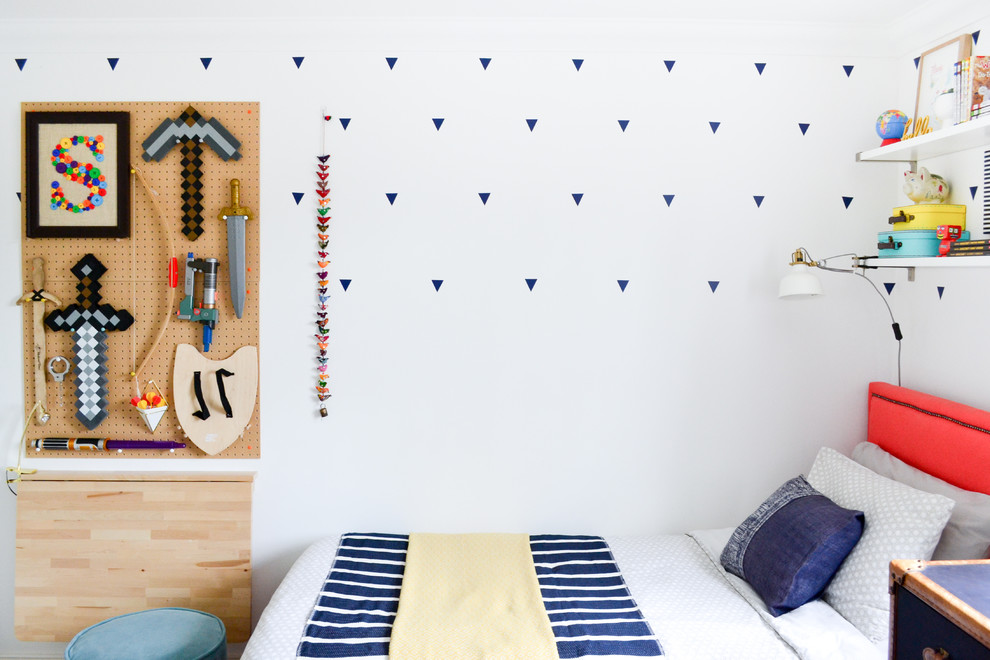 Small eclectic gender neutral children’s room in London with white walls and carpet.