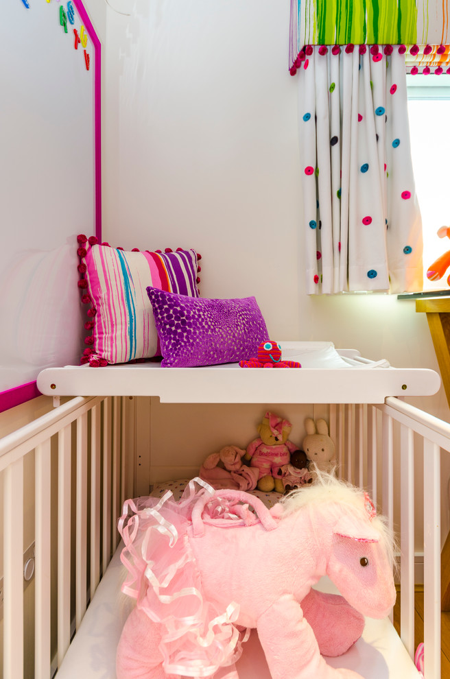 Foto på ett litet funkis barnrum kombinerat med sovrum, med vita väggar och mellanmörkt trägolv