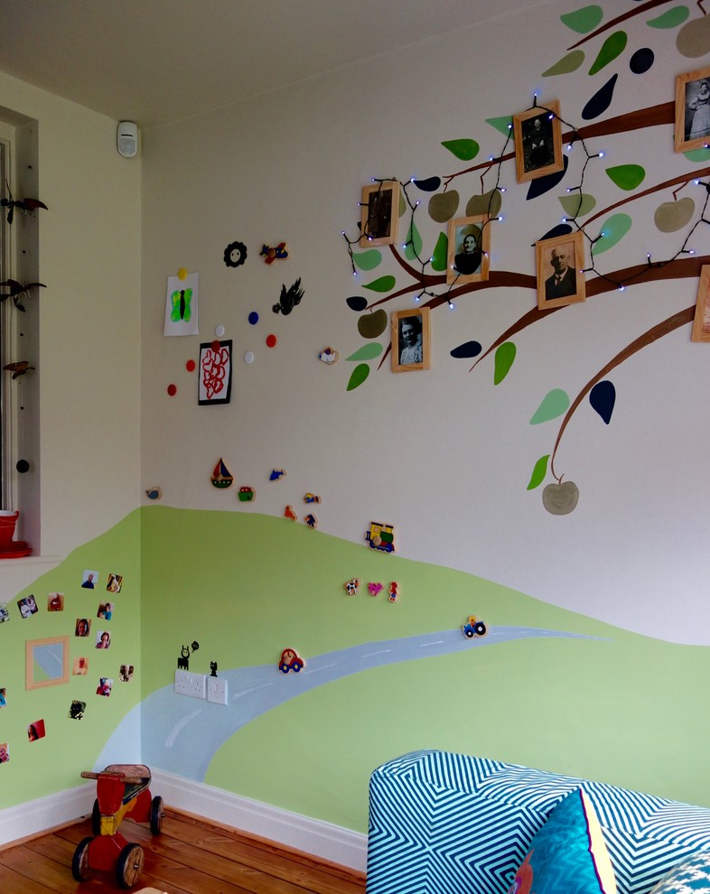 Inredning av ett eklektiskt litet könsneutralt småbarnsrum kombinerat med lekrum, med flerfärgade väggar och mellanmörkt trägolv