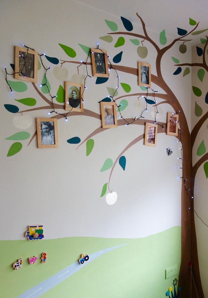 Immagine di una piccola cameretta per bambini da 1 a 3 anni bohémian con pareti multicolore e pavimento in legno massello medio