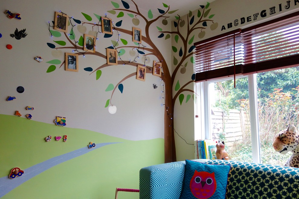 Foto di una piccola cameretta per bambini da 1 a 3 anni eclettica con pareti multicolore e pavimento in legno massello medio