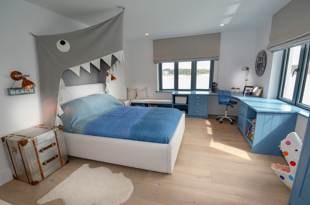 Imagen de dormitorio infantil de 4 a 10 años actual de tamaño medio con paredes blancas, suelo de madera clara y suelo beige