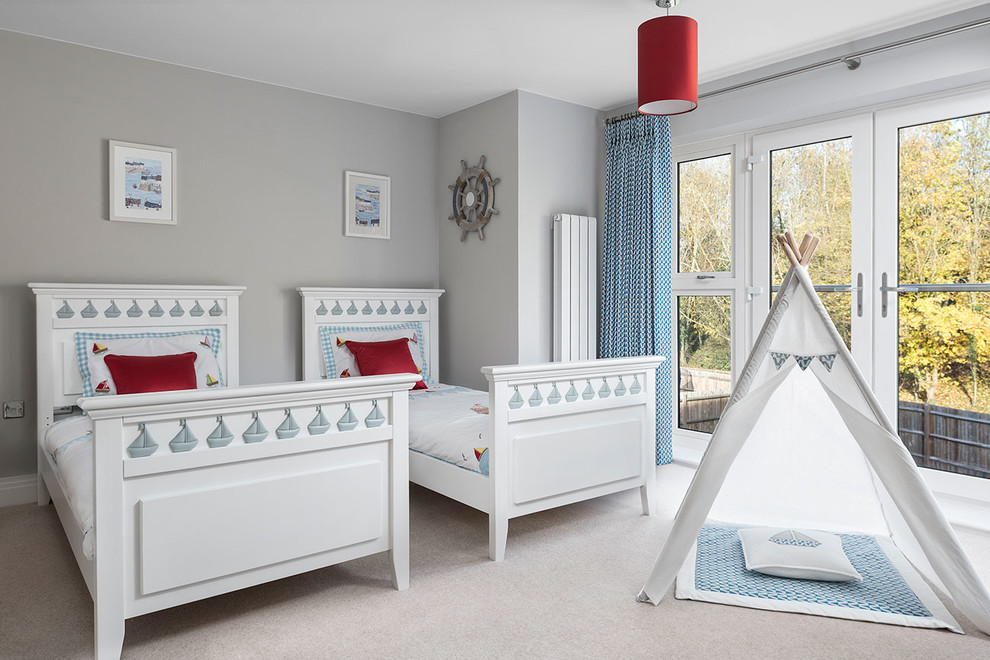 This is an example of a medium sized traditional gender neutral children’s room in Berkshire with grey walls, carpet and beige floors.