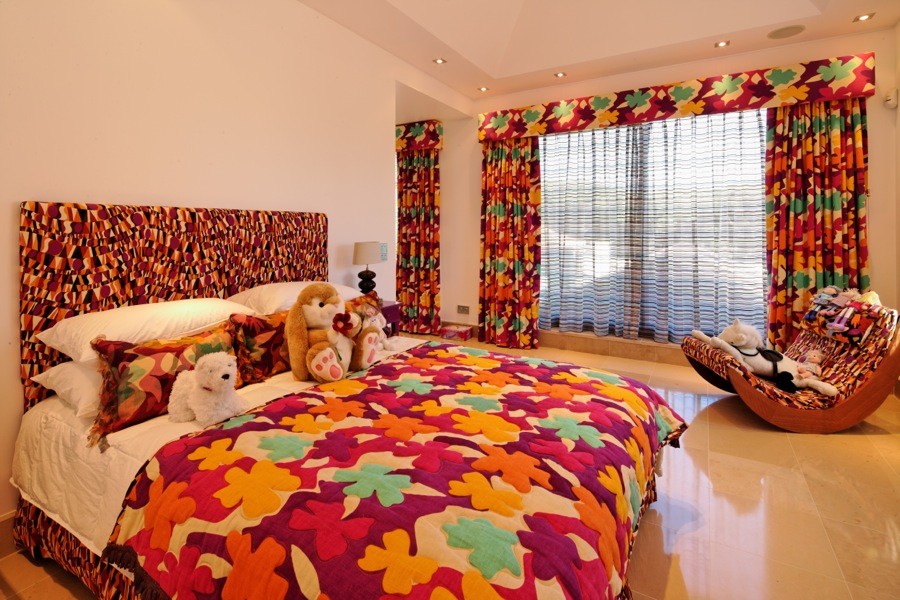 Bild på ett stort tropiskt barnrum kombinerat med sovrum, med beige väggar och kalkstensgolv