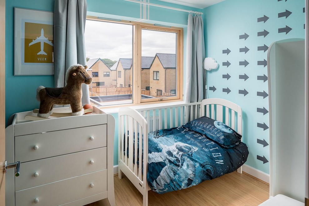 Diseño de dormitorio infantil de 4 a 10 años contemporáneo pequeño con paredes azules, suelo beige y suelo de madera clara