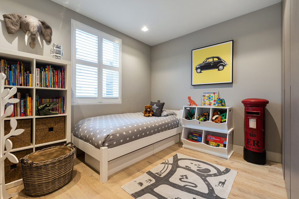 Example of a mid-sized trendy boy light wood floor kids' room design in West Midlands with gray walls