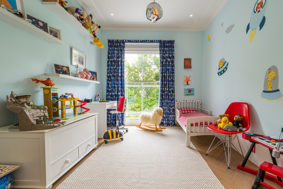 Inspiration for a medium sized traditional children’s room for boys in London with blue walls, light hardwood flooring and brown floors.