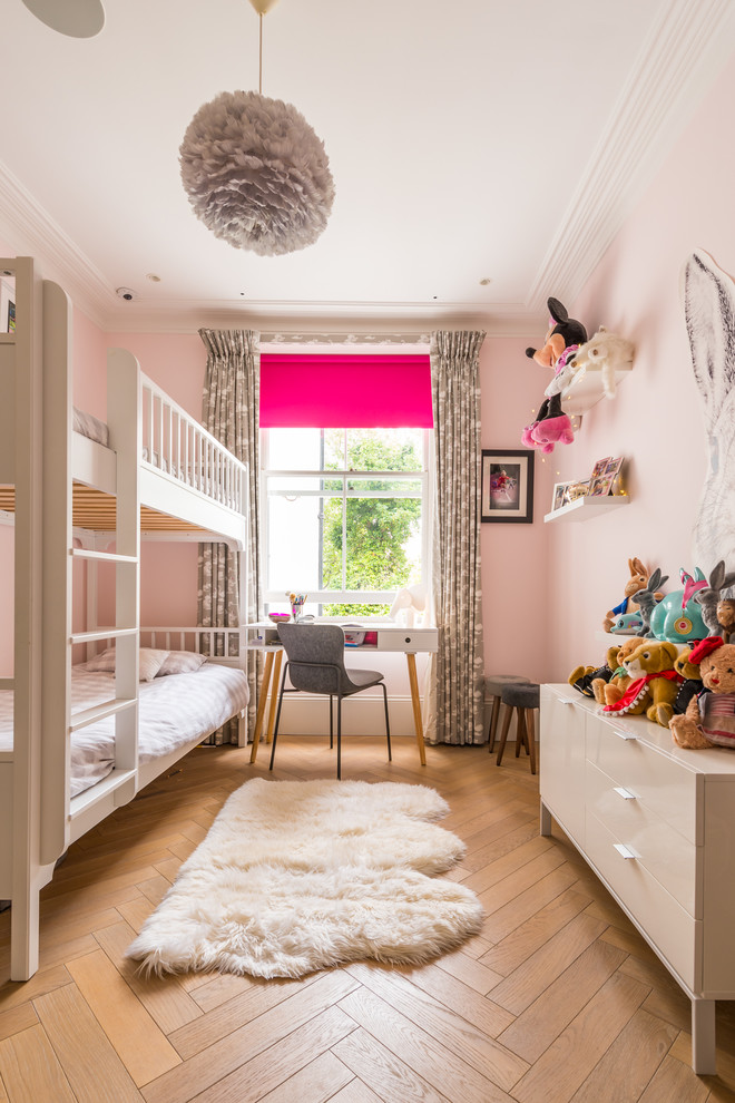 Klassisk inredning av ett flickrum kombinerat med sovrum och för 4-10-åringar, med rosa väggar, ljust trägolv och beiget golv