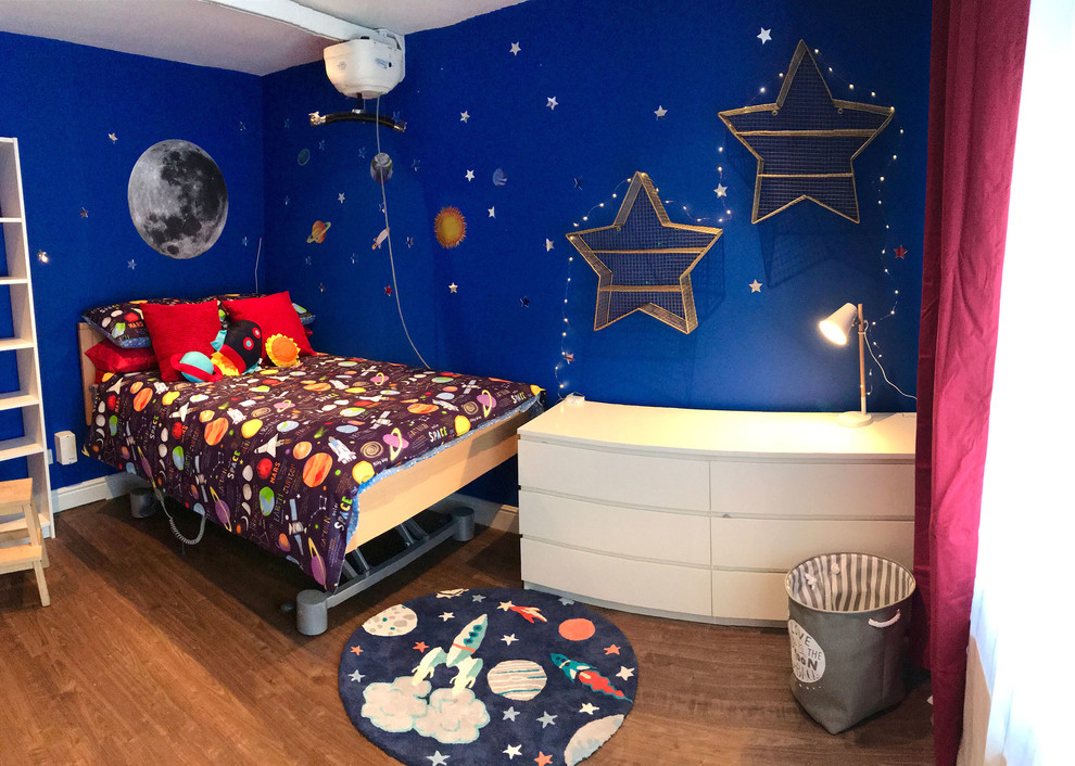 Bild på ett mellanstort funkis pojkrum kombinerat med sovrum och för 4-10-åringar, med blå väggar, laminatgolv och brunt golv