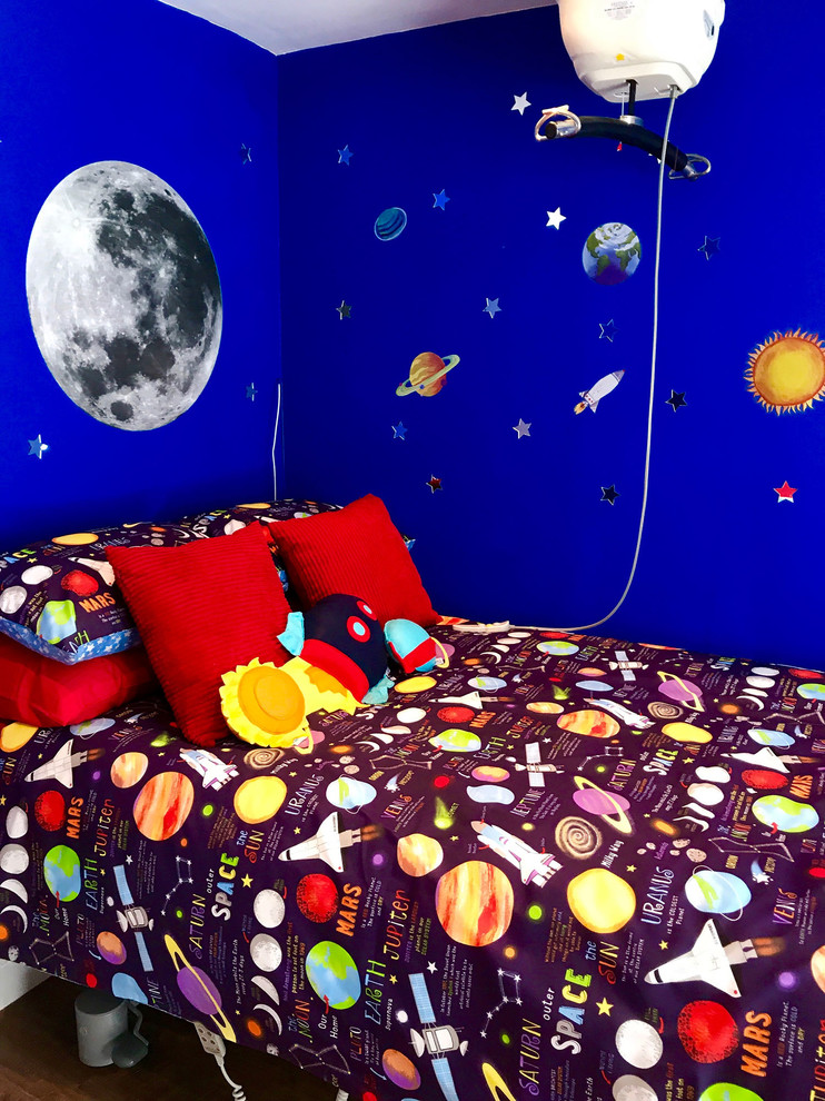 Foto på ett mellanstort funkis pojkrum kombinerat med sovrum och för 4-10-åringar, med blå väggar, laminatgolv och brunt golv