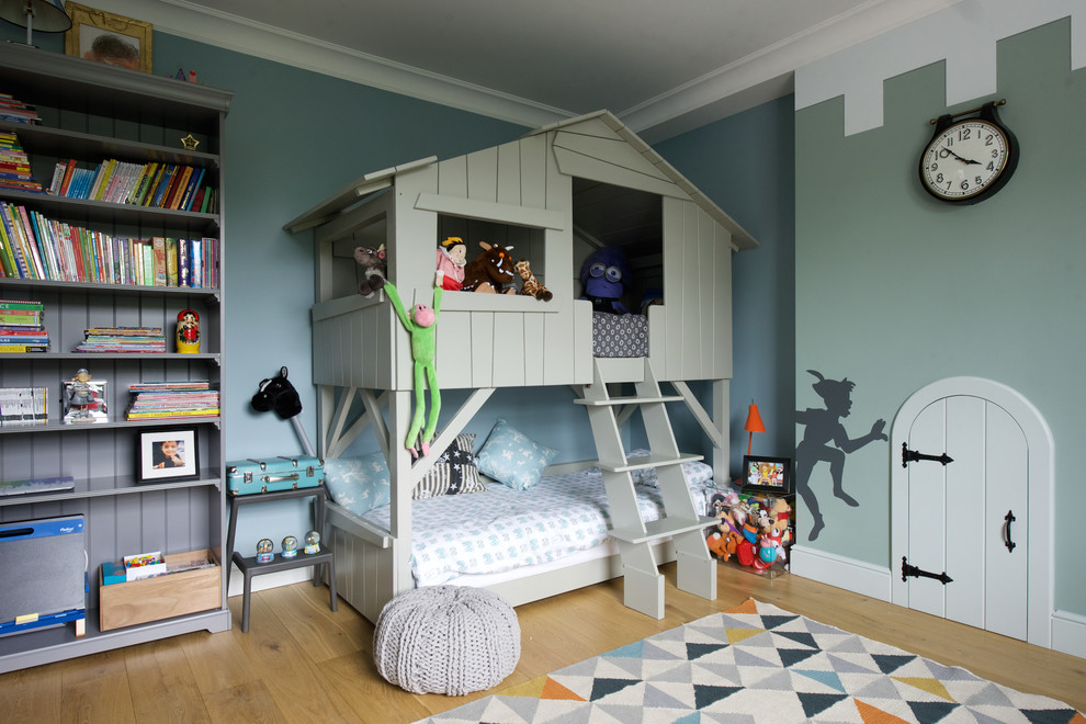 Mid-sized elegant boy medium tone wood floor kids' room photo in London with multicolored walls