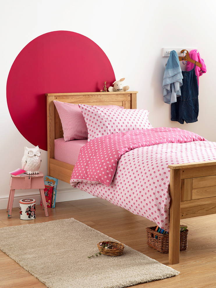 Ejemplo de dormitorio infantil contemporáneo con paredes rosas y suelo de madera en tonos medios