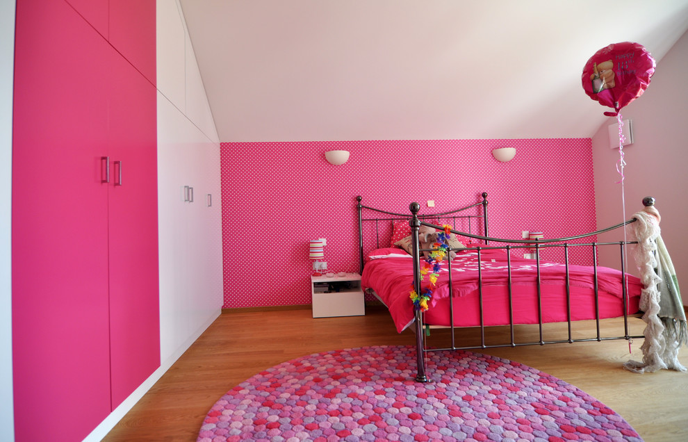 Medium sized contemporary teen’s room for girls in London with medium hardwood flooring and multi-coloured walls.