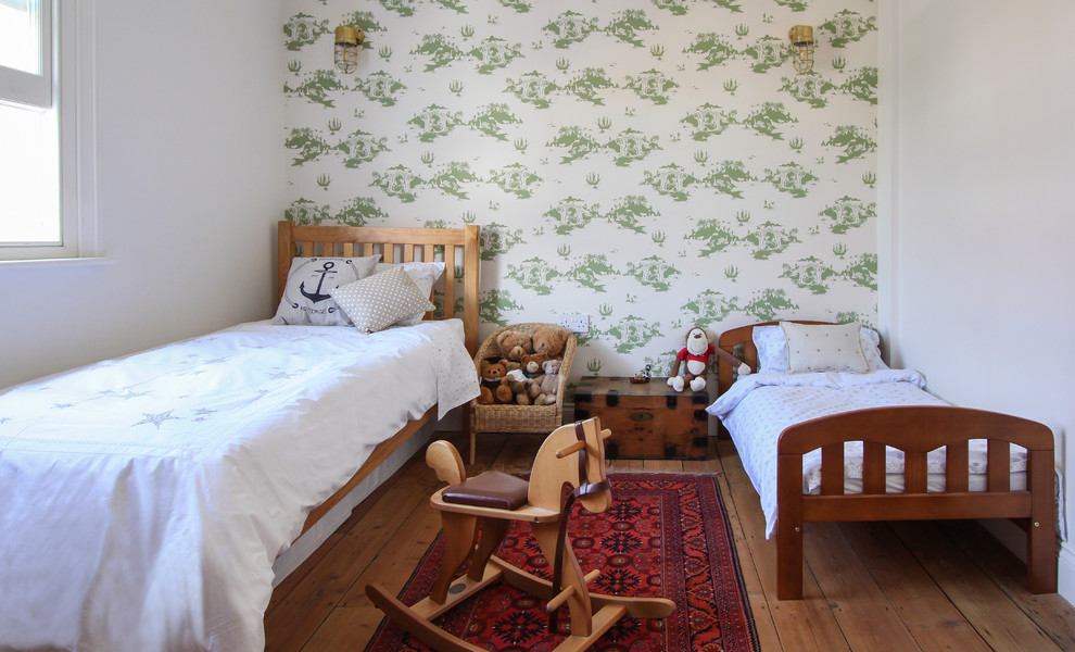 Exempel på ett litet modernt könsneutralt barnrum kombinerat med sovrum, med vita väggar och mellanmörkt trägolv