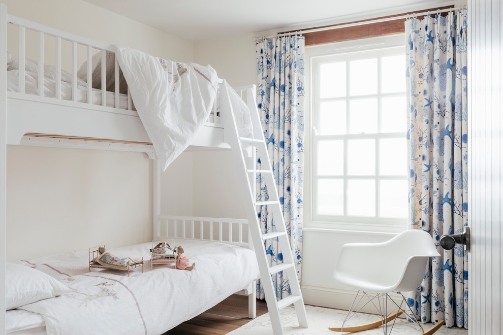 Design ideas for a medium sized nautical kids' bedroom for girls in Cornwall with white walls, medium hardwood flooring and brown floors.