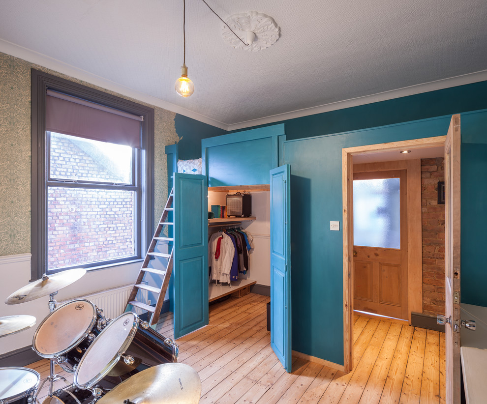 Inredning av ett klassiskt mellanstort tonårsrum, med blå väggar och ljust trägolv