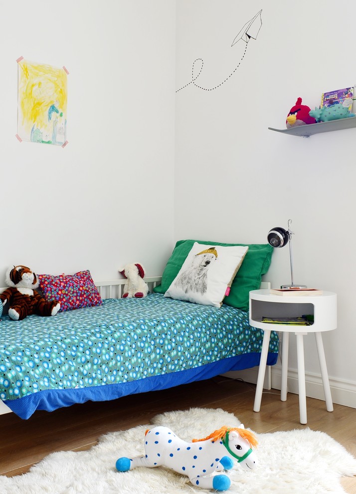 Foto på ett skandinaviskt pojkrum kombinerat med sovrum och för 4-10-åringar, med vita väggar och ljust trägolv