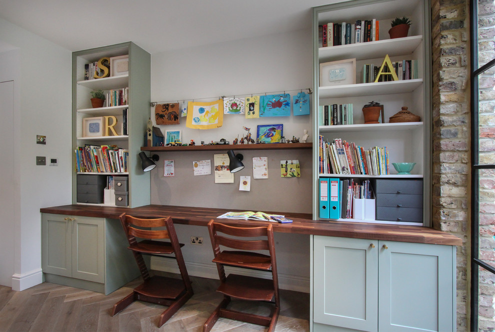 Diseño de habitación infantil unisex de 4 a 10 años contemporánea de tamaño medio con suelo de madera clara, escritorio y paredes blancas
