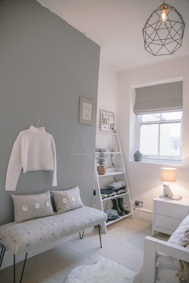 Bild på ett litet minimalistiskt barnrum, med grå väggar och heltäckningsmatta