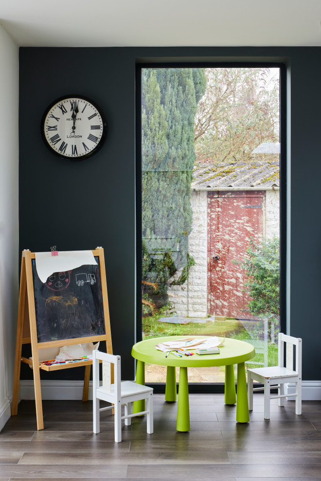 Exemple d'une petite chambre d'enfant de 4 à 10 ans tendance avec un mur bleu, un sol en bois brun et un sol marron.