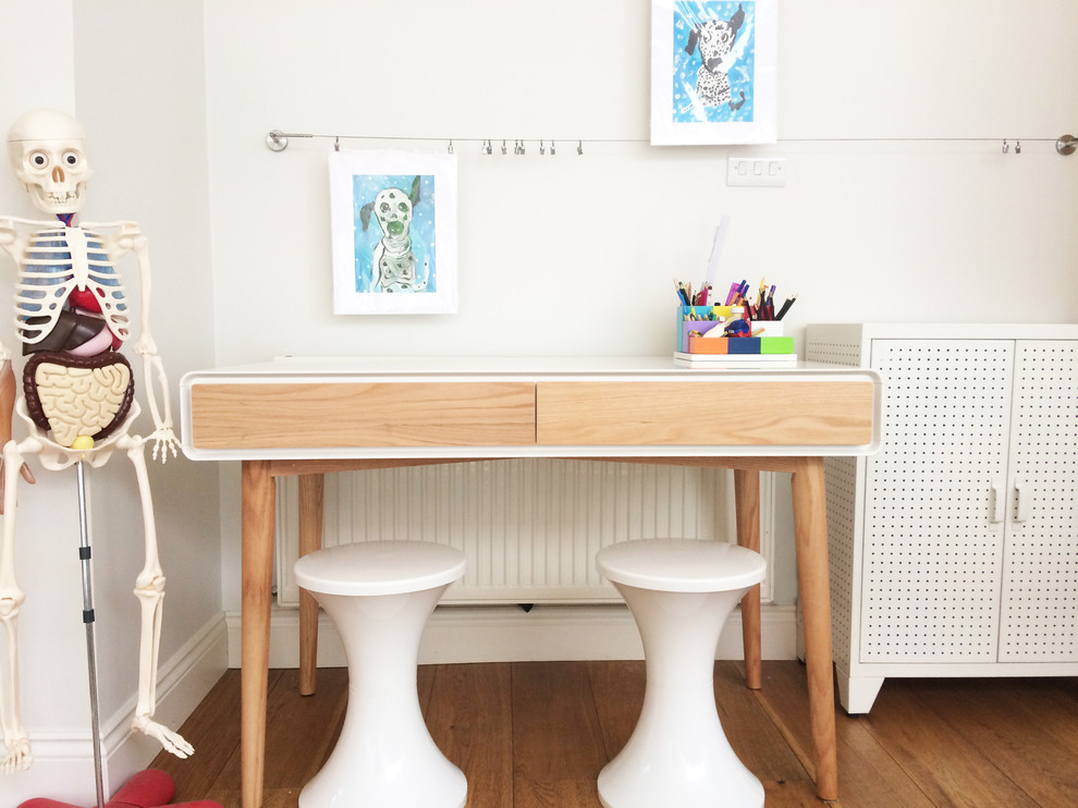 Inspiration för ett litet funkis könsneutralt barnrum kombinerat med skrivbord och för 4-10-åringar, med vita väggar och ljust trägolv