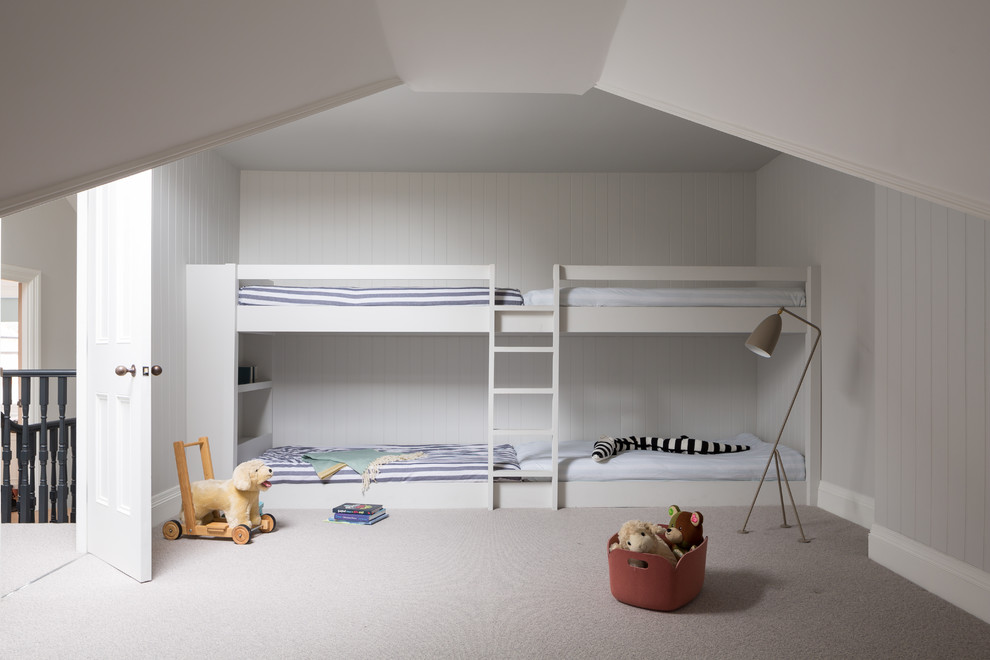 This is an example of a contemporary toddler’s room for boys in London with grey walls, carpet and grey floors.
