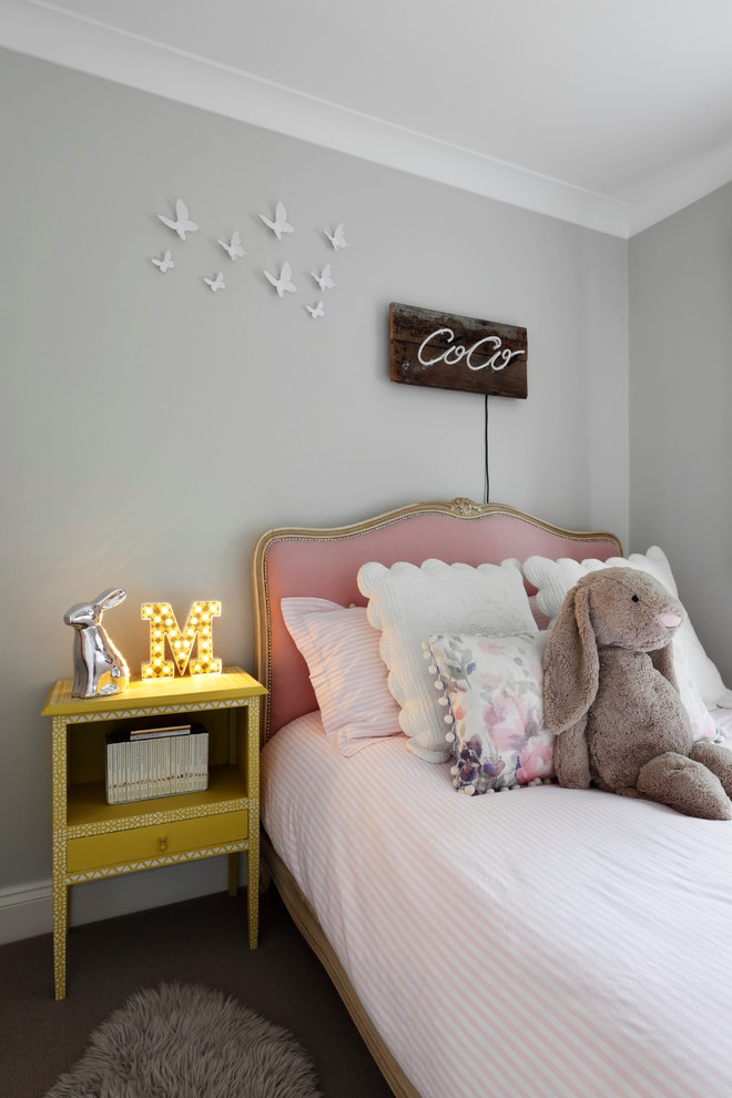 This is an example of a small traditional children’s room for girls in London with grey walls and carpet.