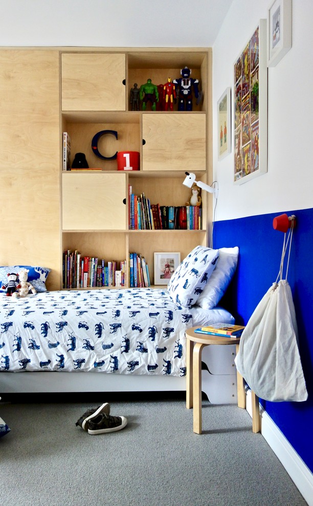 Exempel på ett mellanstort nordiskt könsneutralt barnrum kombinerat med sovrum och för 4-10-åringar, med vita väggar, heltäckningsmatta och grått golv