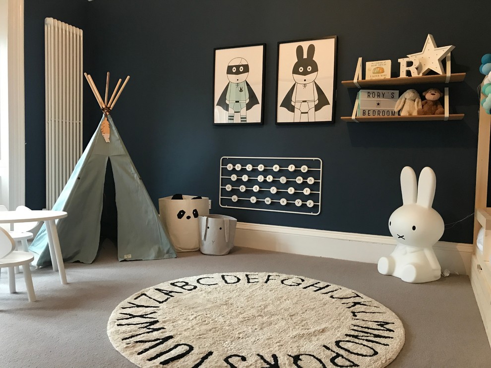 This is an example of a medium sized scandinavian gender neutral kids' bedroom in Glasgow with blue walls, carpet and beige floors.