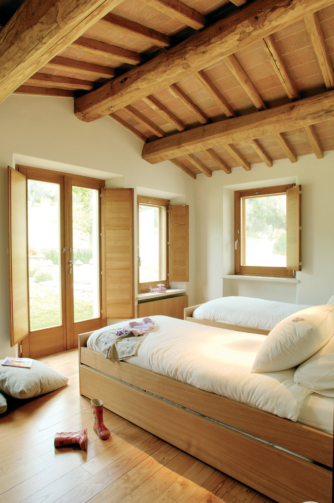 Imagen de dormitorio infantil de 4 a 10 años de estilo de casa de campo de tamaño medio con paredes blancas y suelo de madera clara