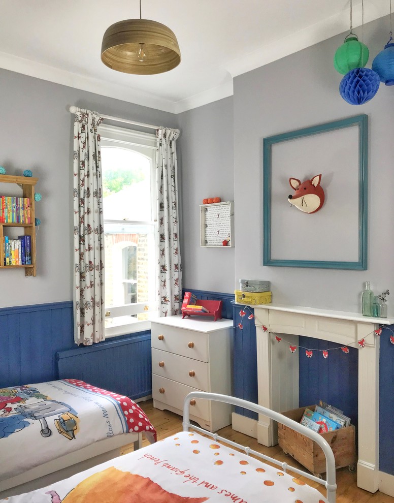 Exempel på ett klassiskt könsneutralt barnrum kombinerat med sovrum och för 4-10-åringar, med blå väggar, mellanmörkt trägolv och brunt golv