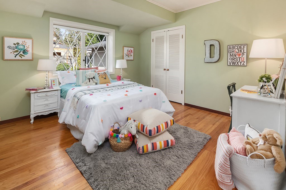 Cette photo montre une grande chambre d'enfant de 4 à 10 ans chic avec un mur vert et un sol en bois brun.