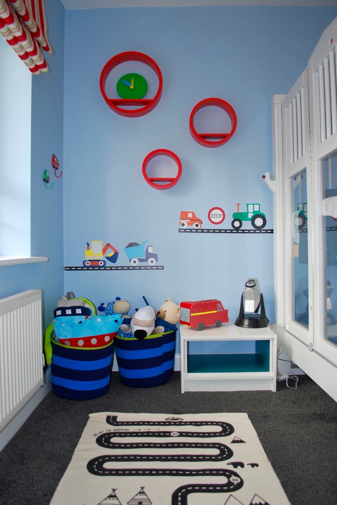 Immagine di una cameretta per bambini da 4 a 10 anni moderna di medie dimensioni con pareti blu, moquette e pavimento grigio