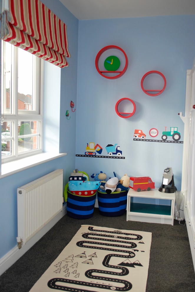 This is an example of a medium sized modern children’s room for boys in London with blue walls, carpet and grey floors.