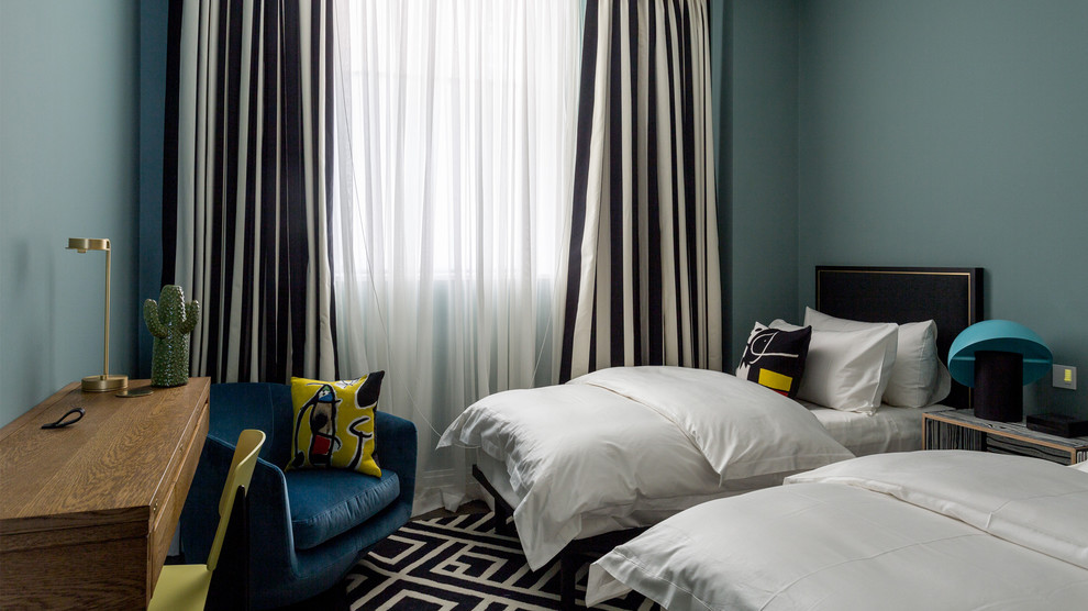 Modern inredning av ett mellanstort könsneutralt tonårsrum kombinerat med sovrum, med blå väggar, mörkt trägolv och brunt golv