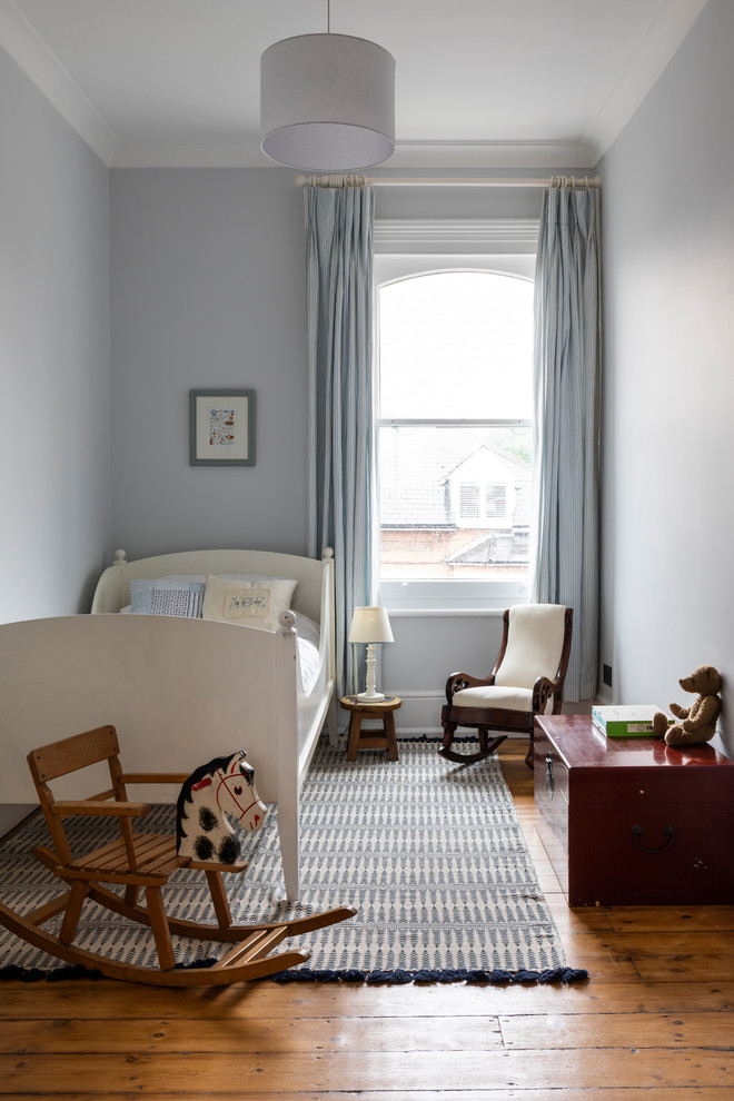 Klassisches Jungszimmer mit Schlafplatz, blauer Wandfarbe, braunem Holzboden und braunem Boden in London