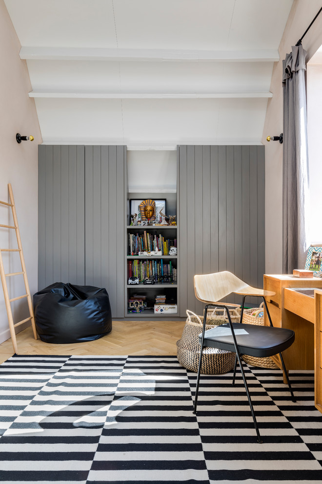 Inspiration for an industrial kids' study space in London with pink walls and light hardwood flooring.