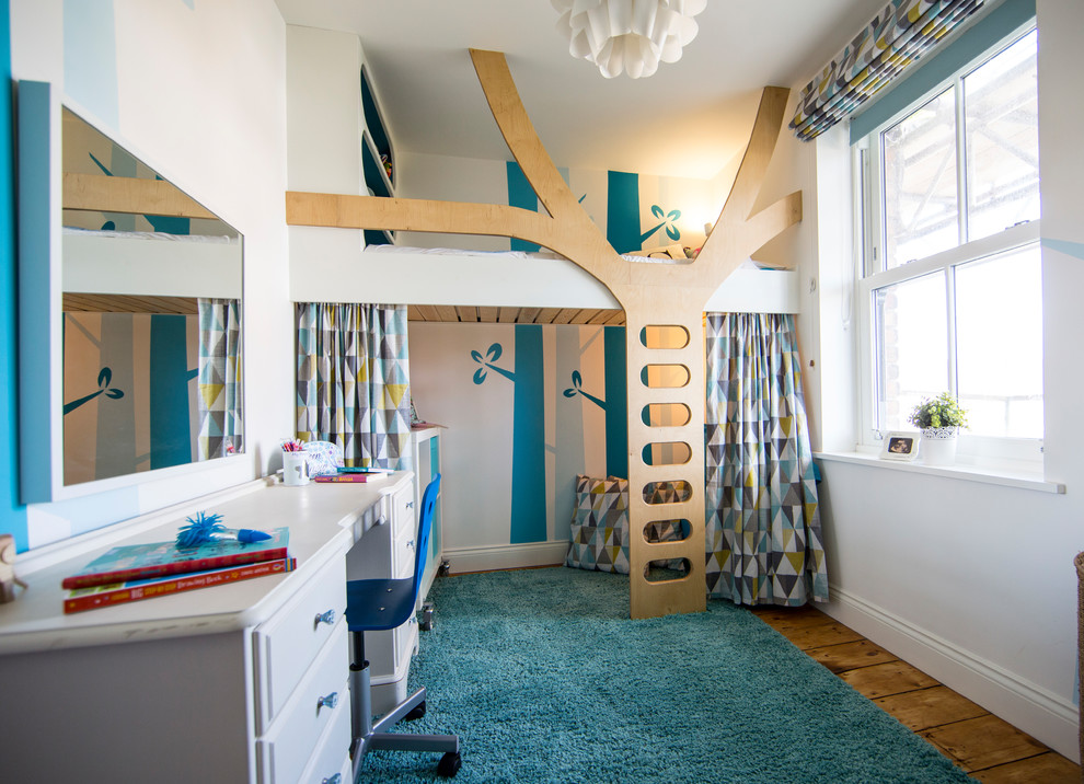 Modelo de dormitorio infantil de 4 a 10 años actual de tamaño medio con paredes azules y suelo de madera en tonos medios