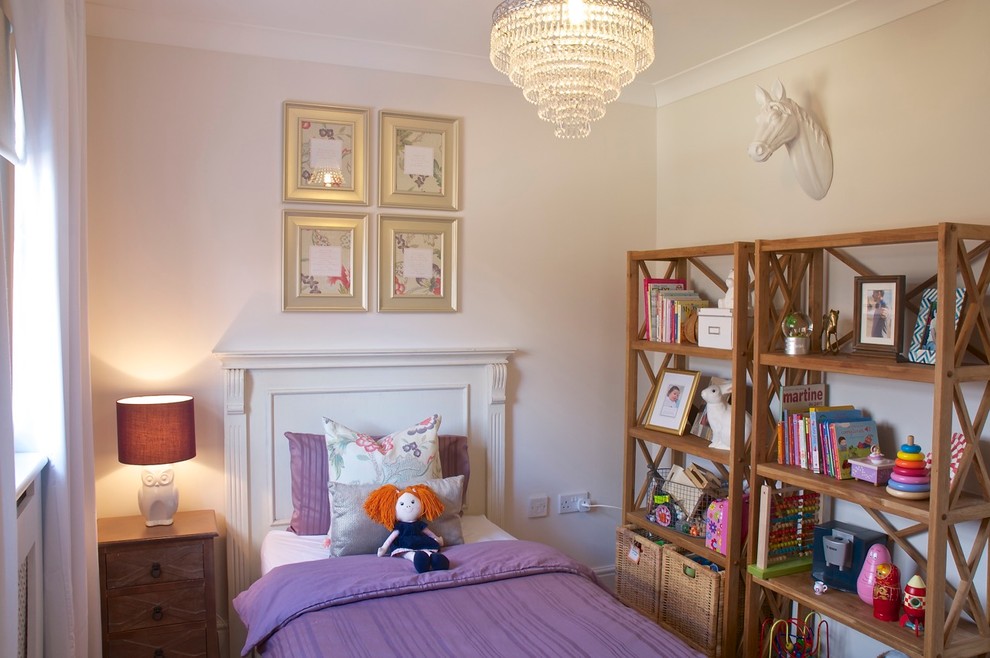 This is an example of a small classic toddler’s room for girls in Berkshire with beige walls and carpet.