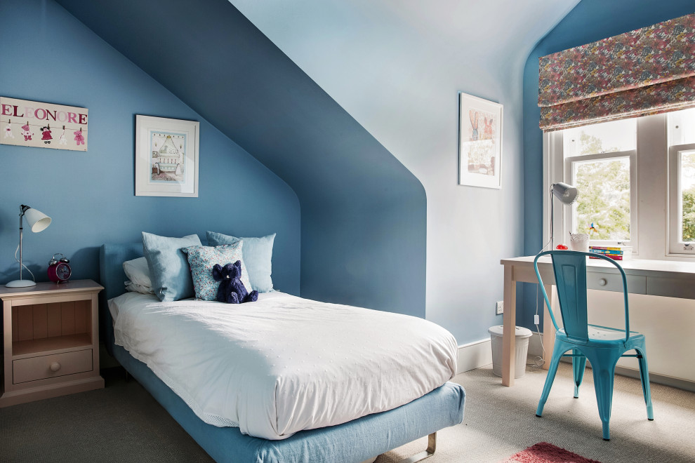 Photo of a contemporary kids' bedroom for boys in London with blue walls, carpet, beige floors and a vaulted ceiling.