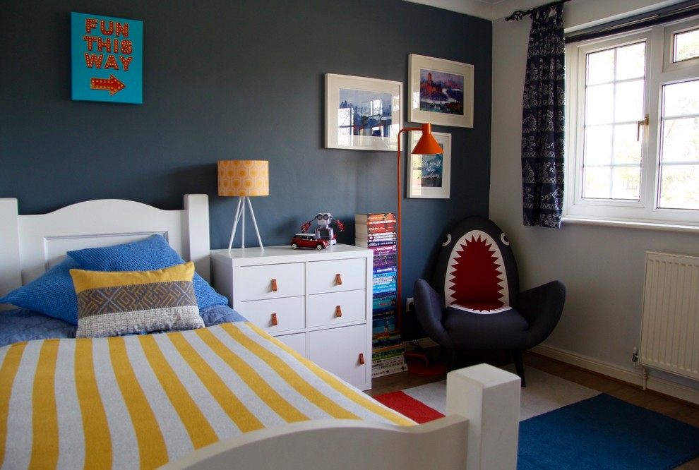 Modelo de dormitorio infantil de 4 a 10 años bohemio pequeño con paredes azules, suelo laminado y suelo marrón
