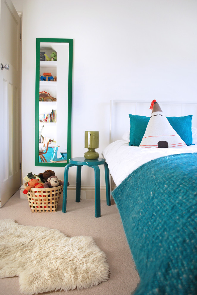 Example of a minimalist boy carpeted kids' room design in Wiltshire with white walls