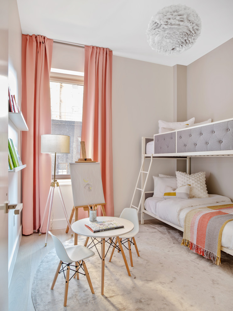 Inspiration for a contemporary children’s room for girls in New York with beige walls, light hardwood flooring and feature lighting.