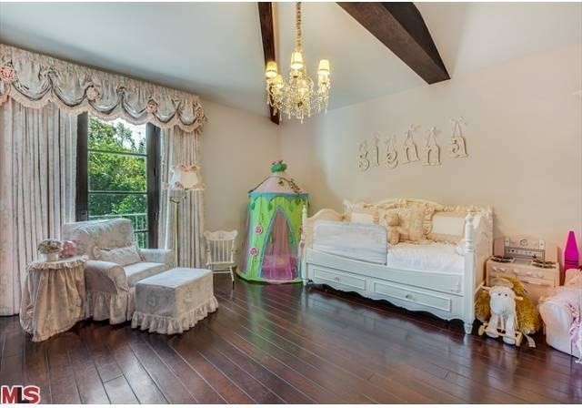 Large classic children’s room for girls in Los Angeles with beige walls and dark hardwood flooring.