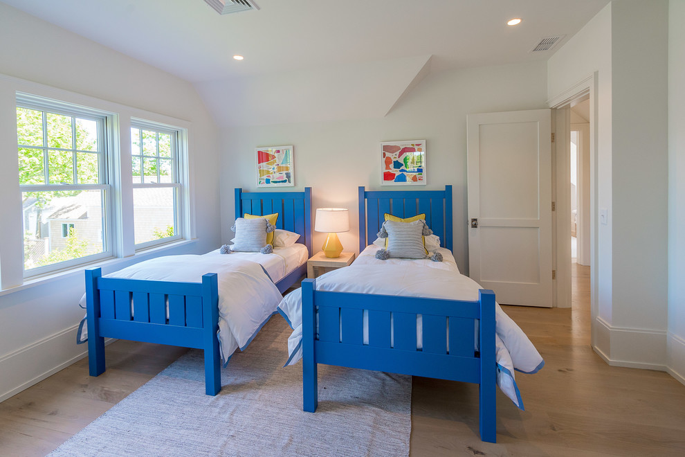 Modelo de dormitorio infantil clásico renovado con paredes blancas, suelo de madera clara y suelo beige