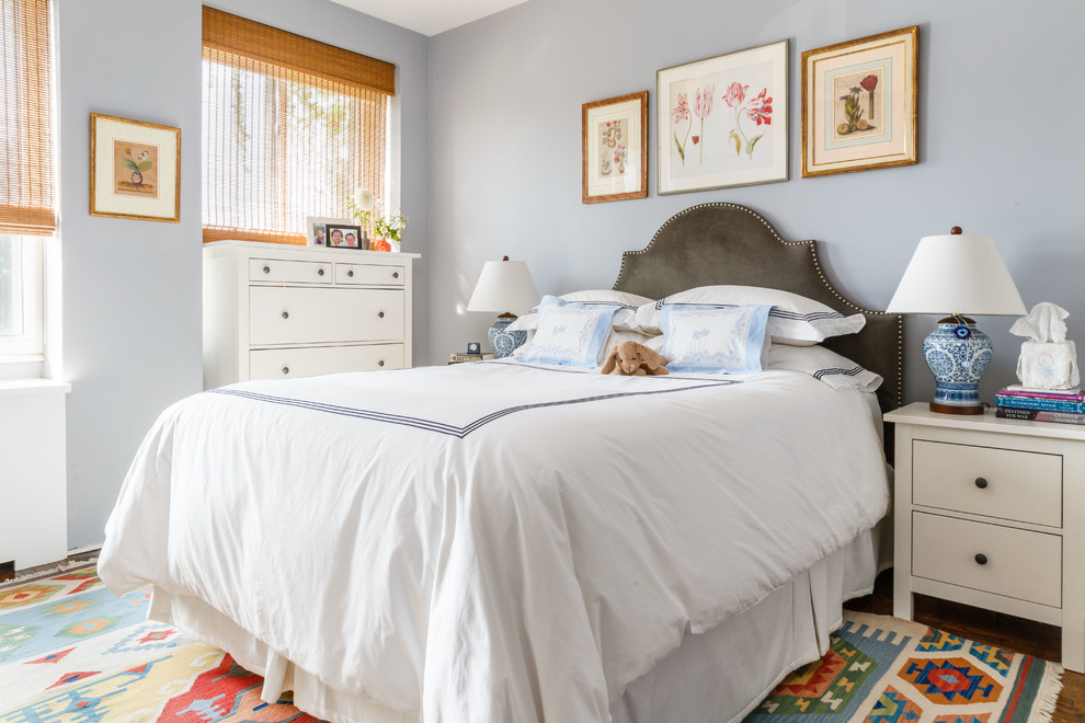 Modelo de dormitorio infantil tradicional renovado con paredes azules, suelo de madera en tonos medios y suelo marrón